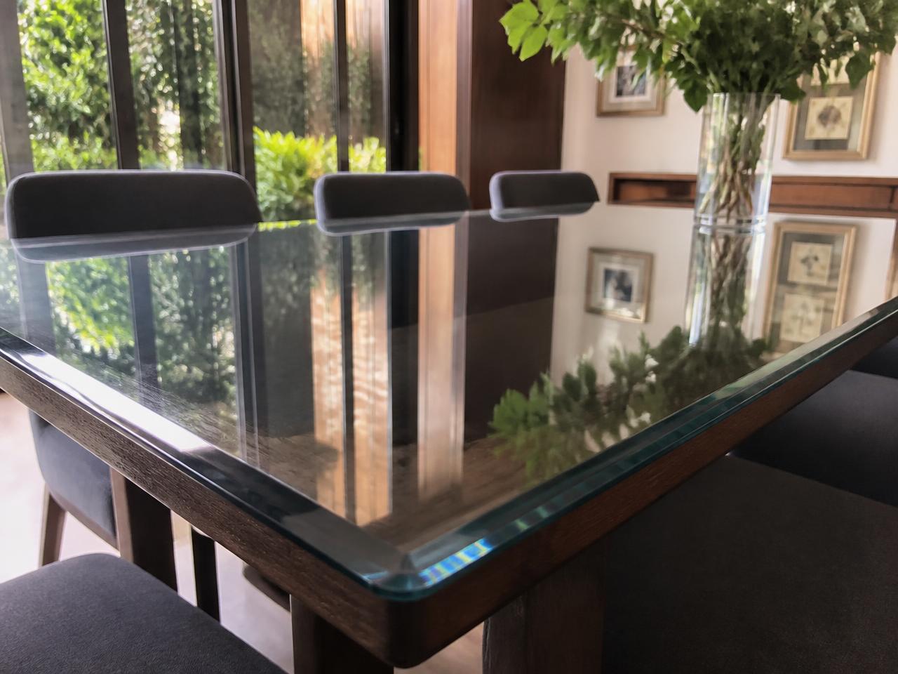 Tempered glass table top with polished beveled edge on a wooden dining table