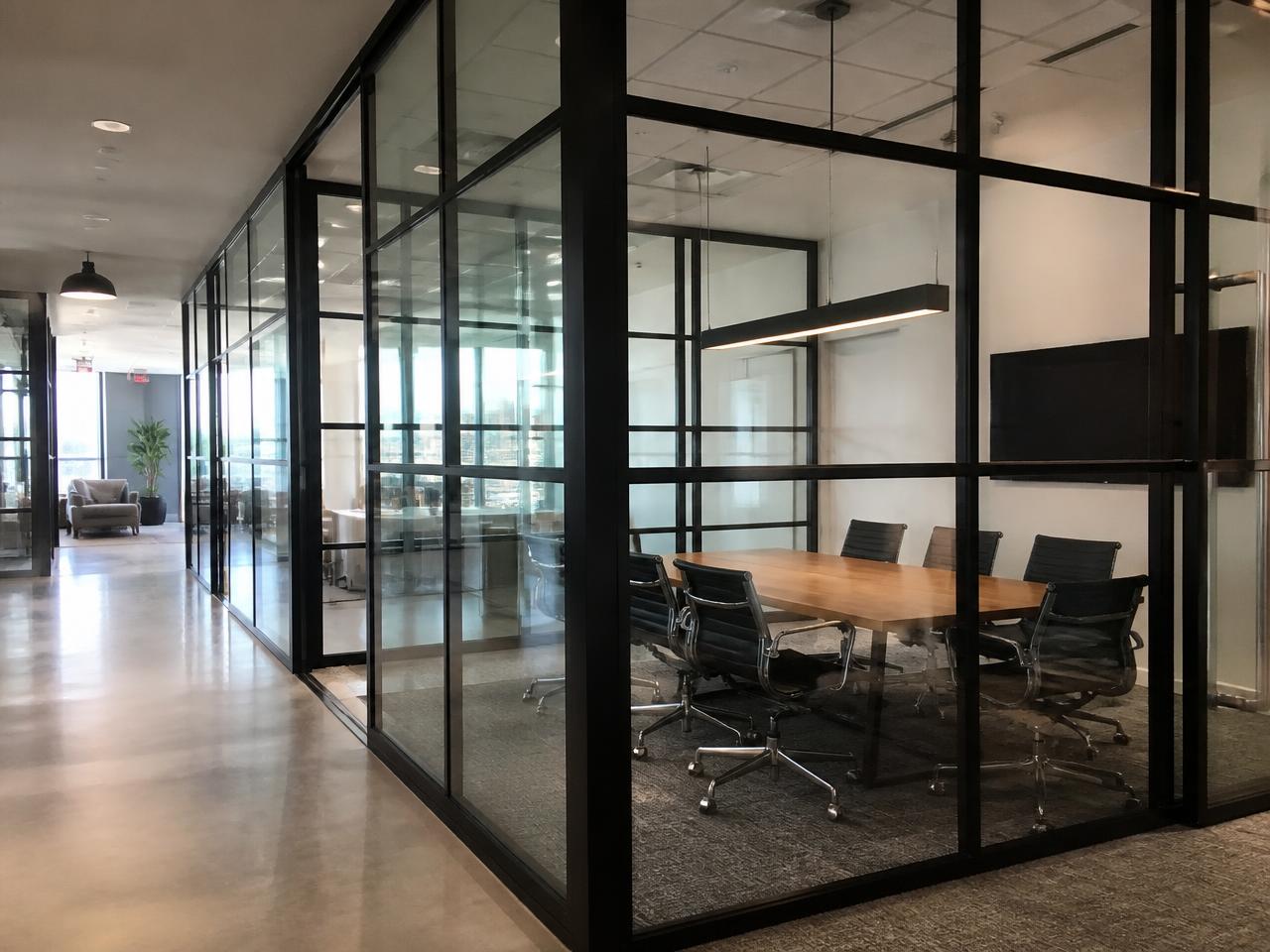 Black-framed interior glass partition walls around an office conference room